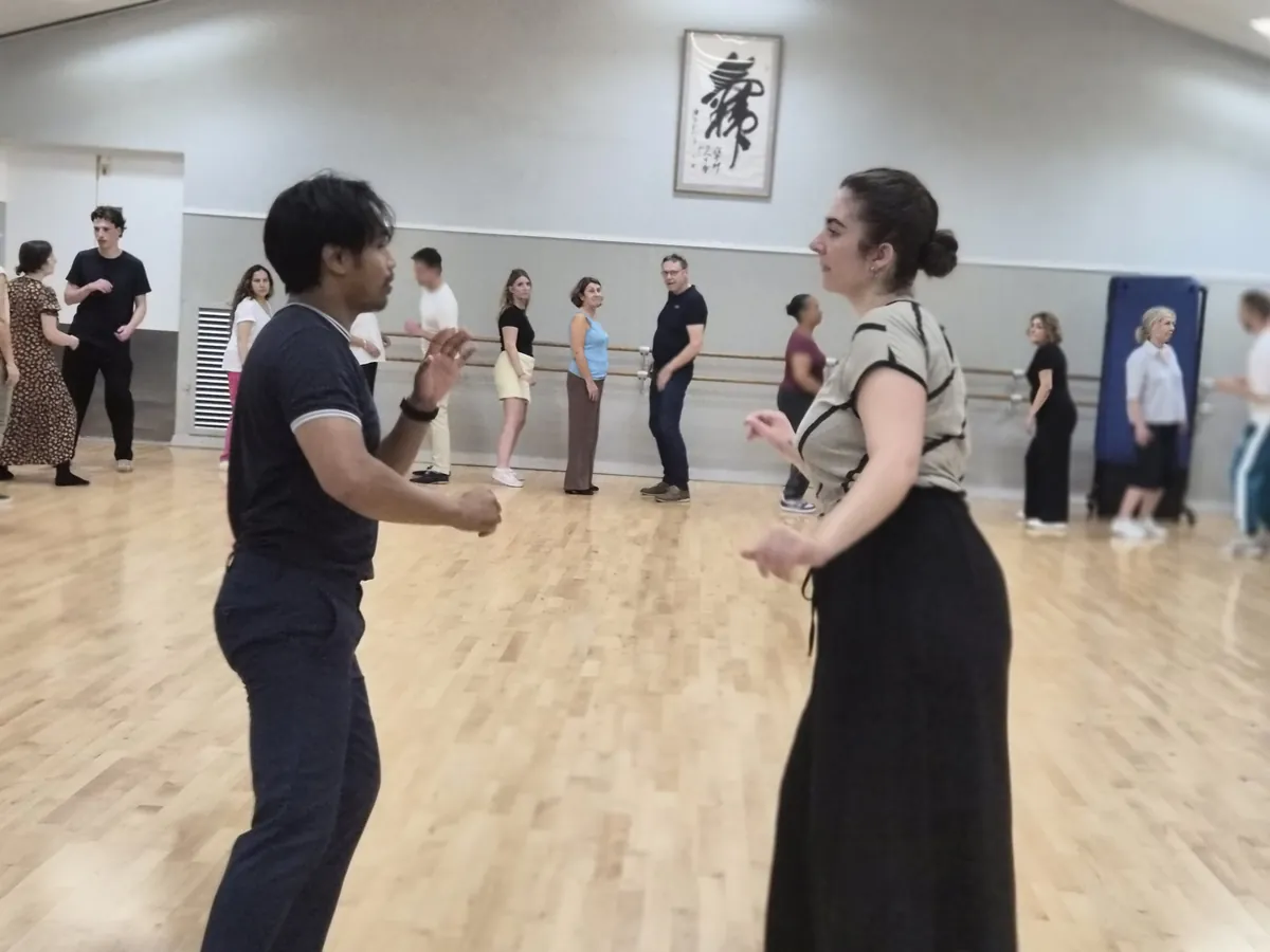 Su Thai et Élo démontrent un pas de bachata devant le groupe d'élèves à Levallois